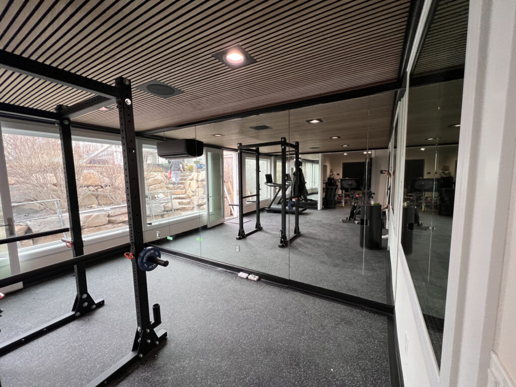 Why Custom Home Builders Choose Jeske Glass for Precise Glass Installations 8 full wall gym mirror with secret door